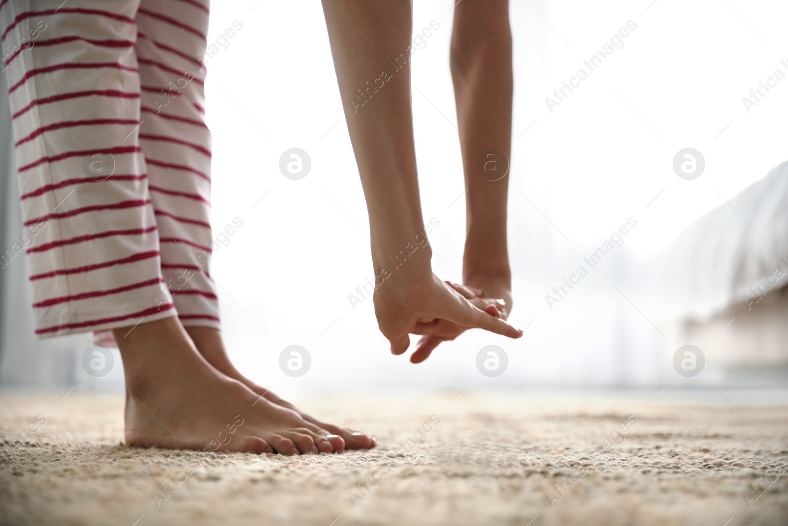 Photo of Young woman stretching at home, closeup. Morning fitness