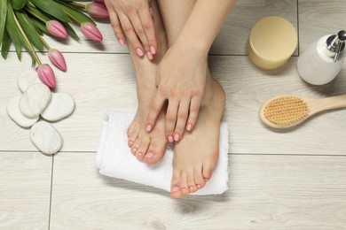 Photo of Closeup of woman with neat toenails after pedicure procedure on light background, top view