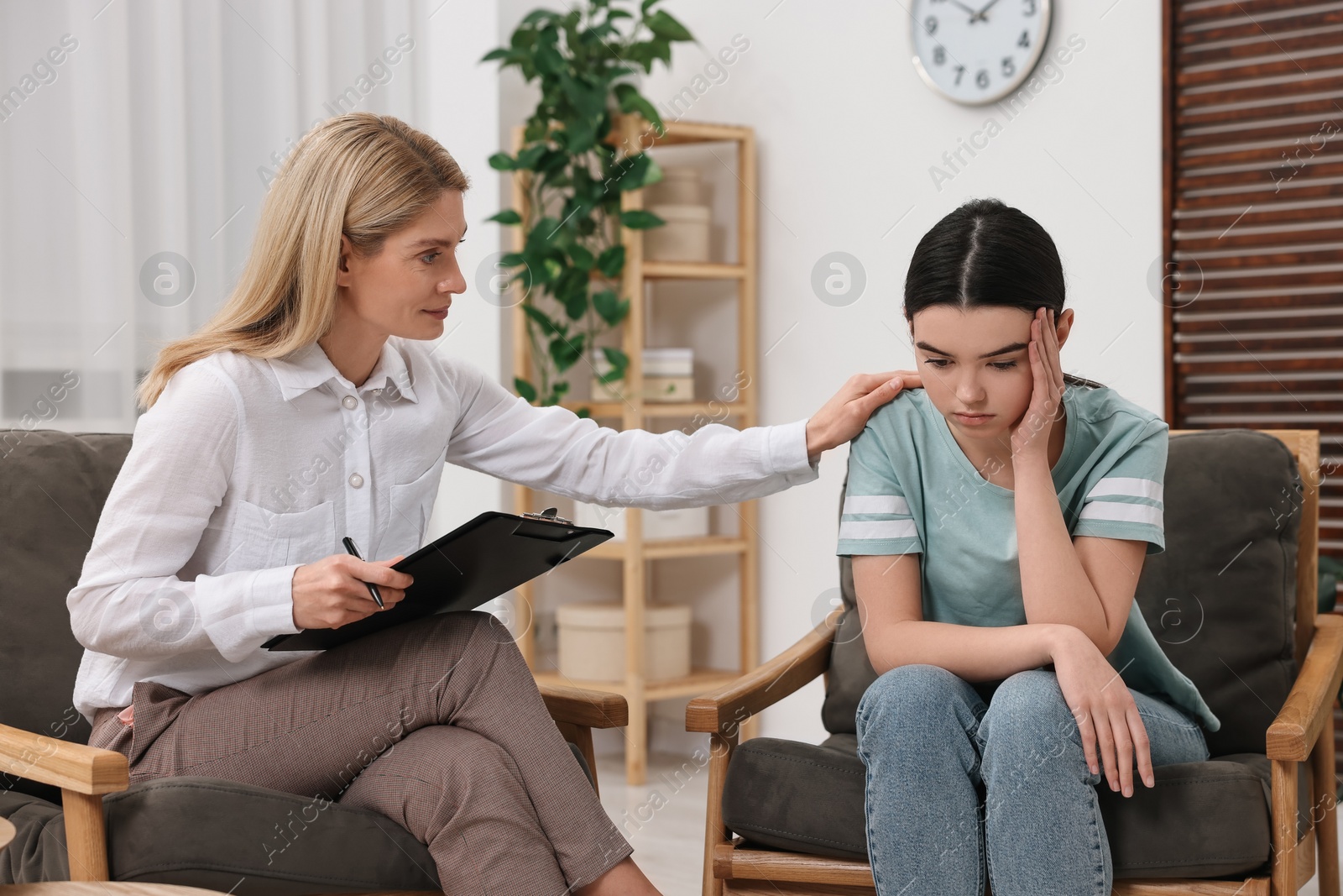 Photo of Psychologist working with teenage girl in office