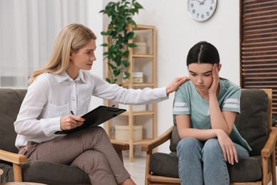 Psychologist working with teenage girl in office