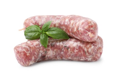 Raw homemade sausages and basil leaves isolated on white