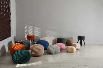 Many stylish different poufs in room. Home design