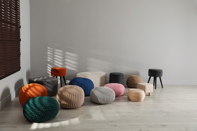 Photo of Many stylish different poufs in room. Home design