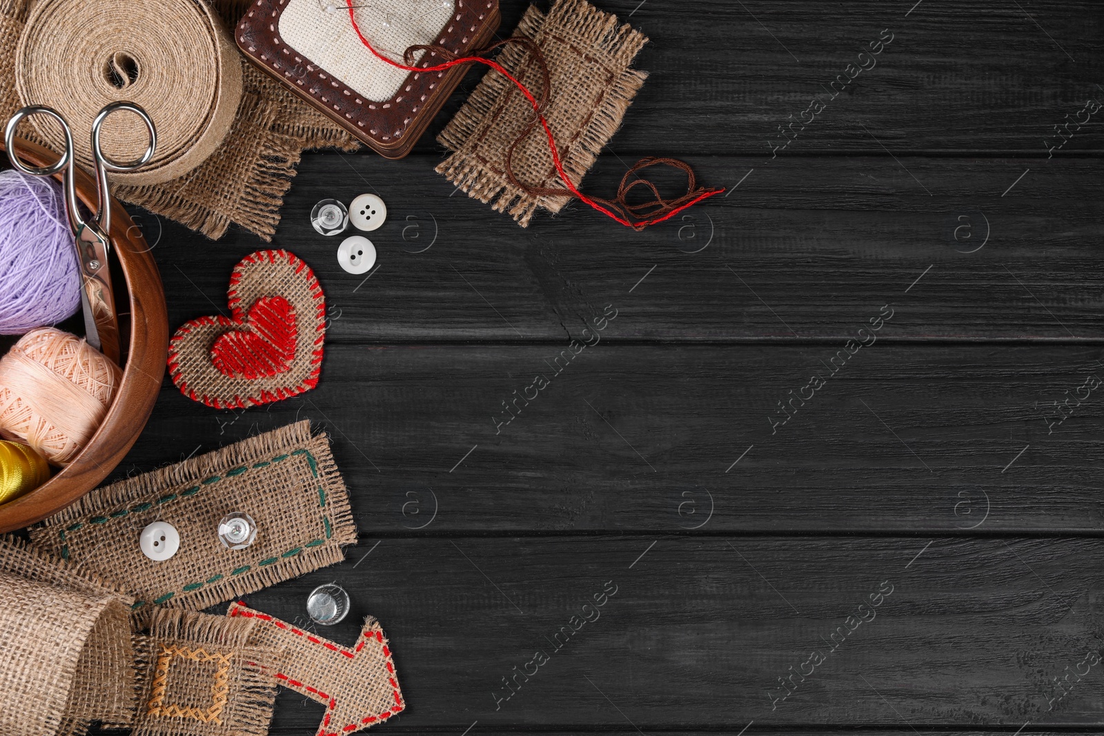 Photo of Flat lay composition with pieces of burlap fabric on black table. Space for text