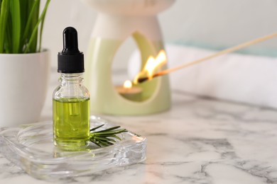 Photo of Aroma lamp and coniferous essential oil on white marble table, space for text