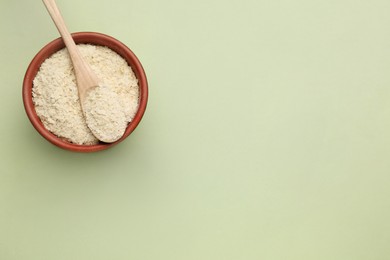 Beer yeast flakes on light green background, top view. Space for text