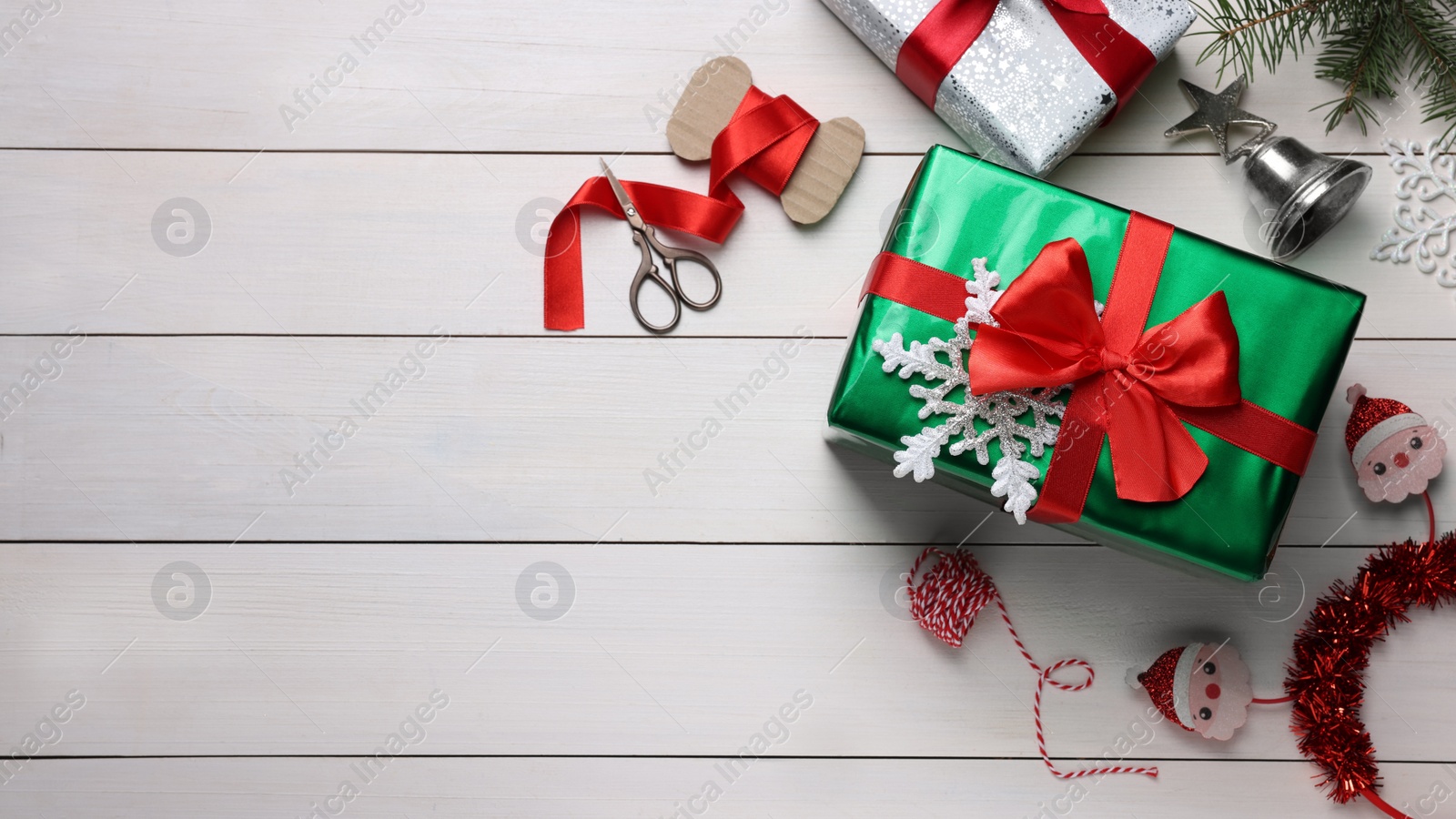 Photo of Flat lay composition with beautifully wrapped gift boxes on white wooden table, space for text
