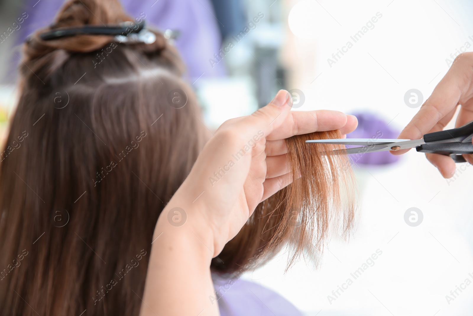 Photo of Professional hairdresser working with client in salon