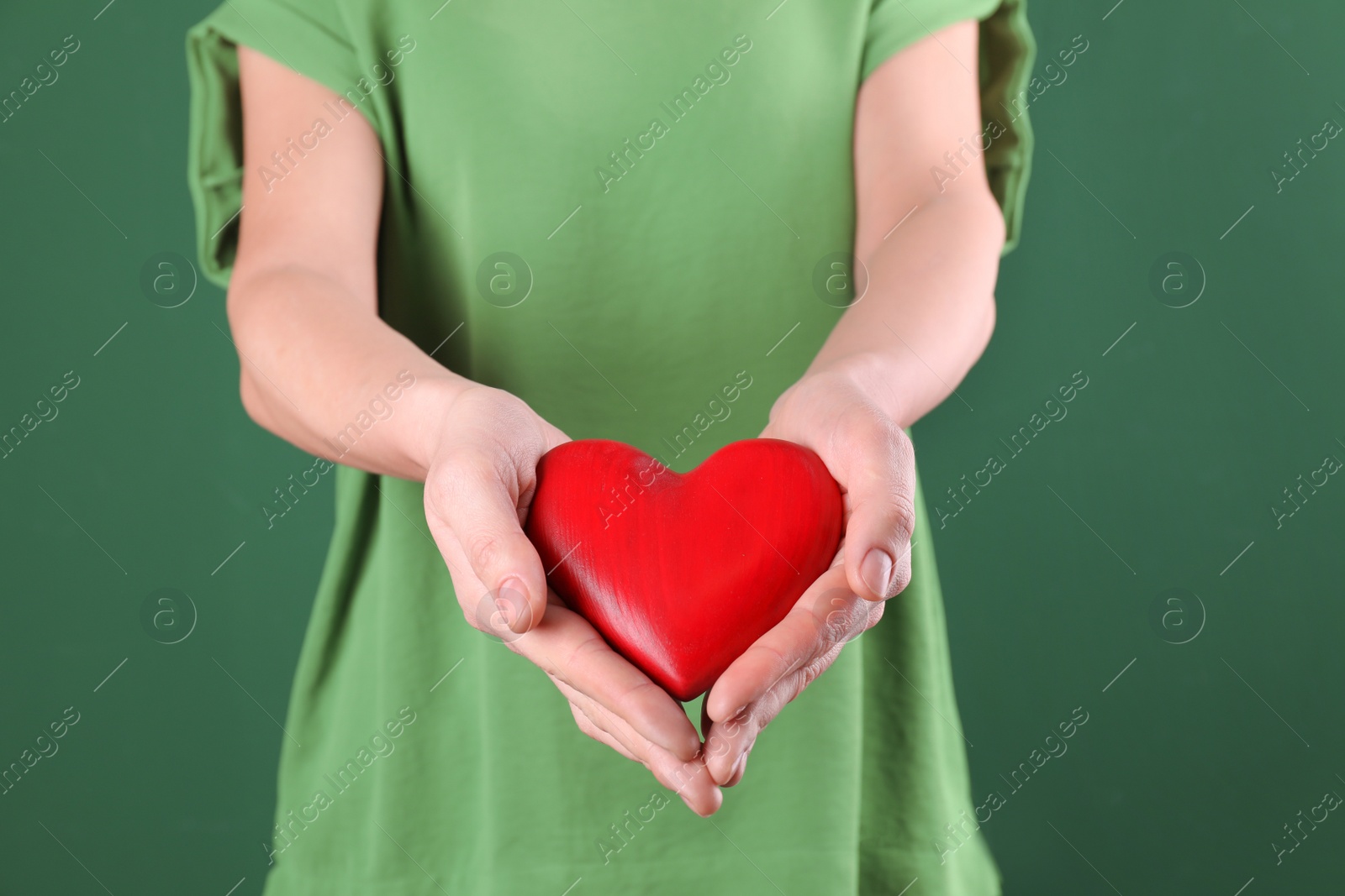 Photo of Woman holding decorative heart on color background, closeup