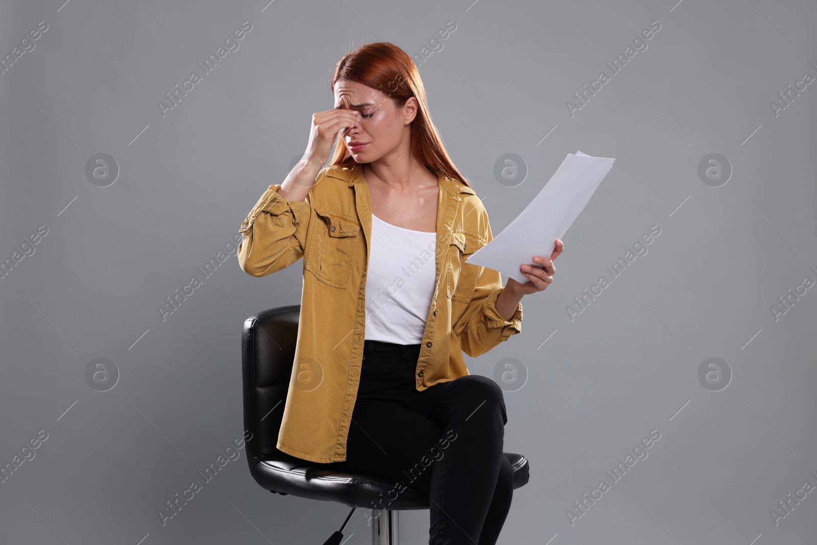 Photo of Casting call. Emotional woman with script performing on grey background