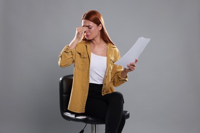 Photo of Casting call. Emotional woman with script performing on grey background
