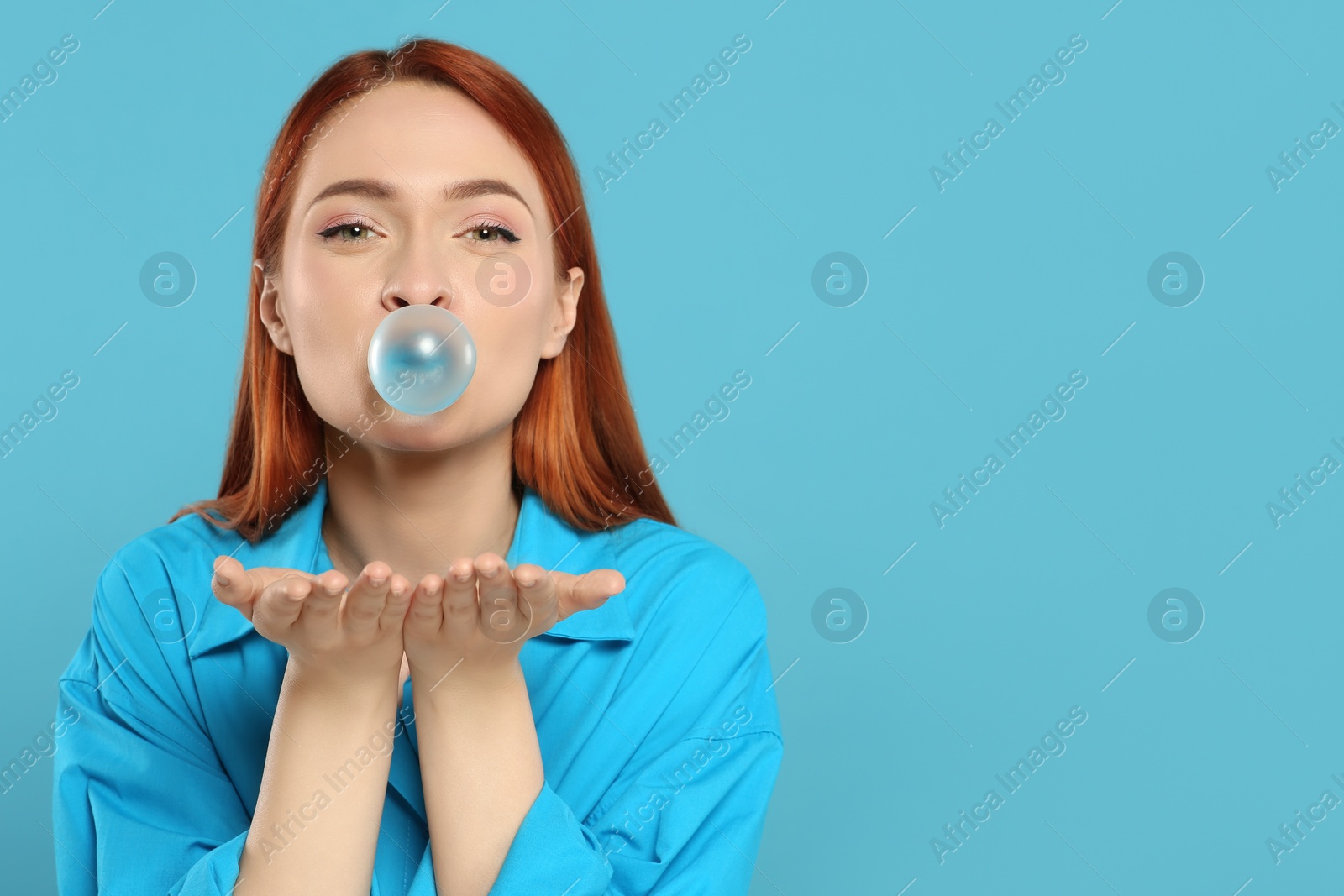 Photo of Beautiful woman blowing bubble gum on turquoise background, space for text