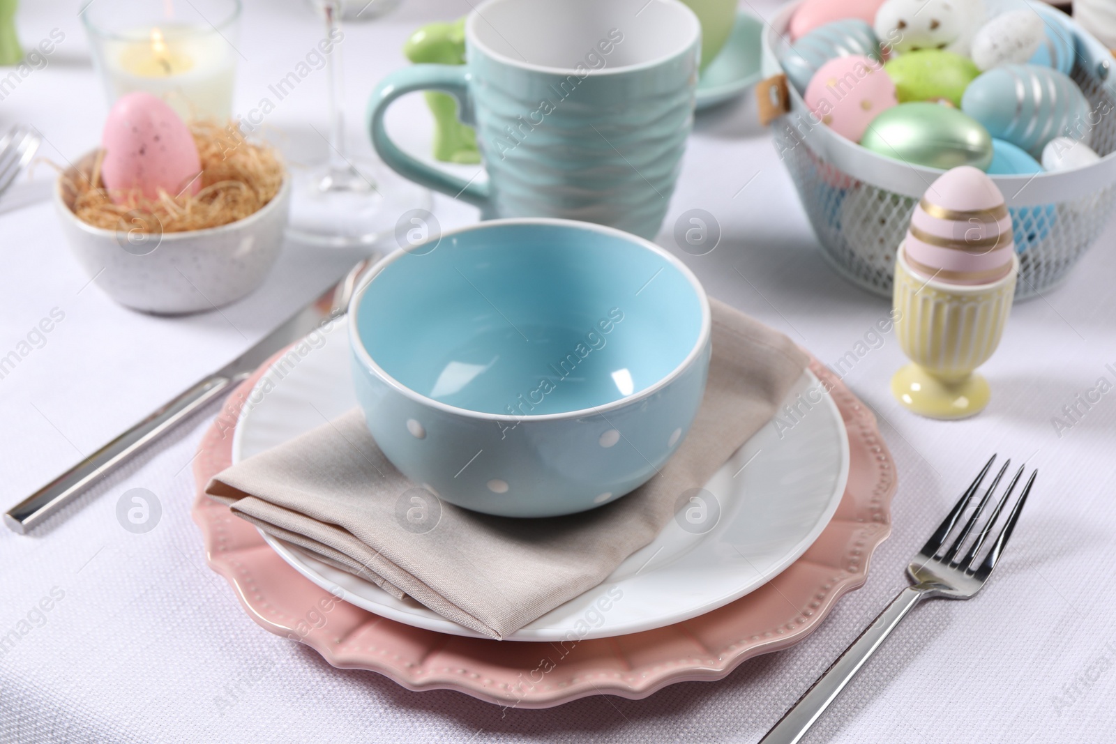 Photo of Festive table setting with painted eggs. Easter celebration