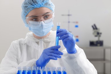 Photo of Scientist holding test tube with sample in laboratory