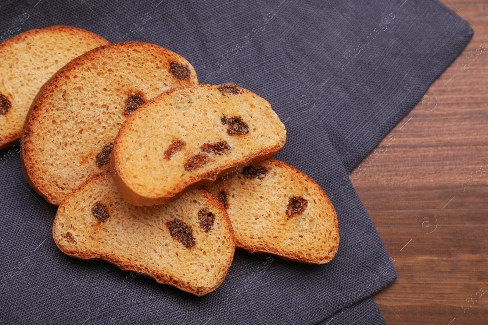 Photo of Sweet hard chuck crackers with raisins on wooden table, flat lay