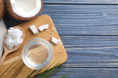 Photo of Flat lay composition with coconut oil on blue wooden table, space for text