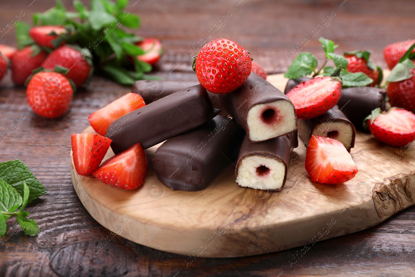 Photo of Delicious glazed curd snacks with fresh strawberries and mint on wooden table