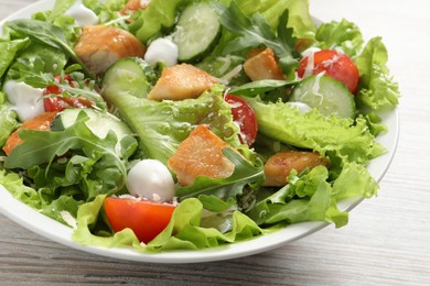 Photo of Delicious salad with chicken and vegetables on table, closeup