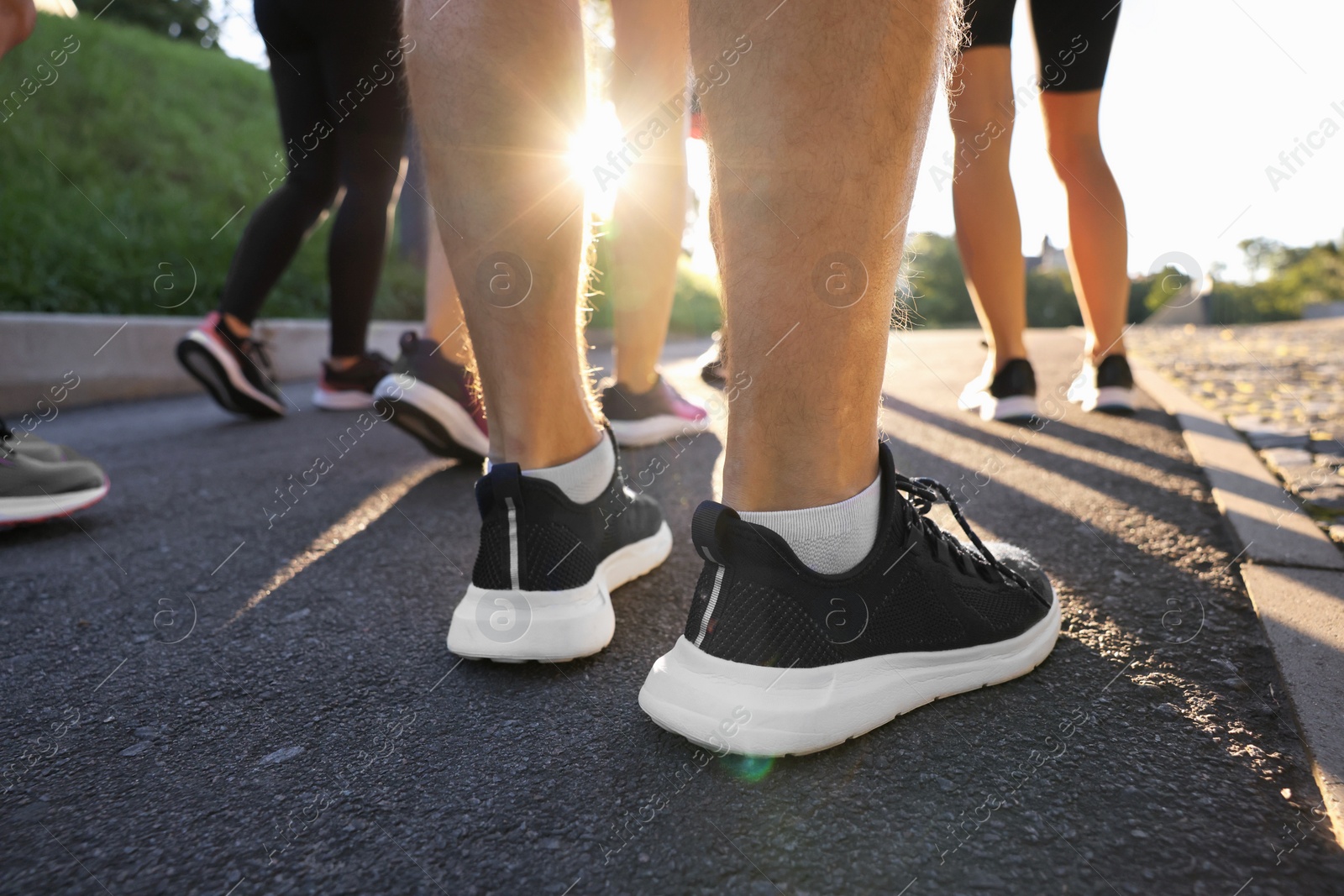 Photo of Group of people resting after run outdoors on sunny day, closeup view