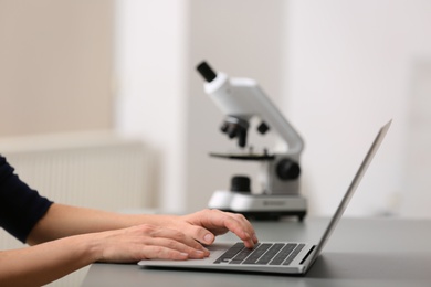 Photo of Female student working with laptop at table. Medical education