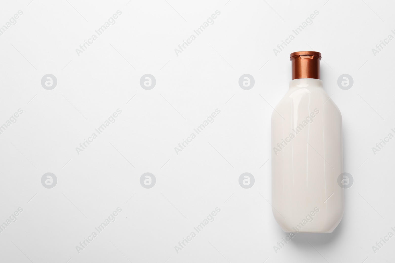 Photo of Bottle of shampoo on white background, top view. Space for text