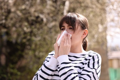 Woman suffering from seasonal allergy in park