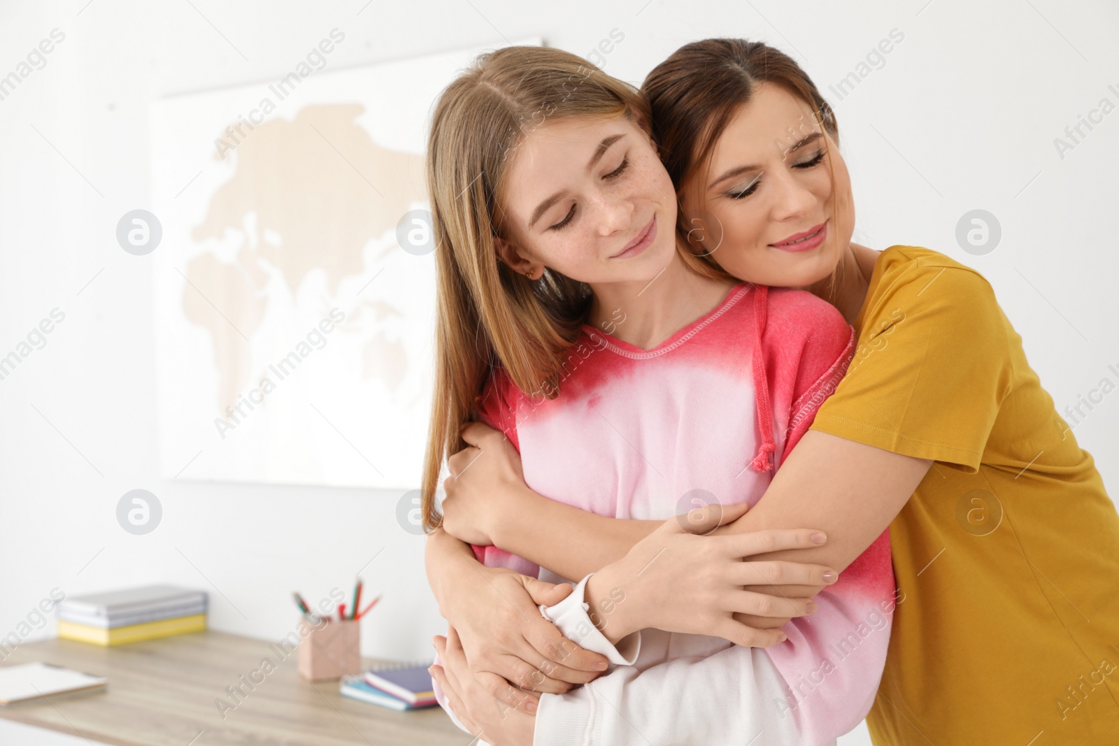 Photo of Happy mother hugging her teenager daughter at home