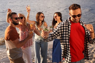 Photo of Man with friends having fun near river at summer party