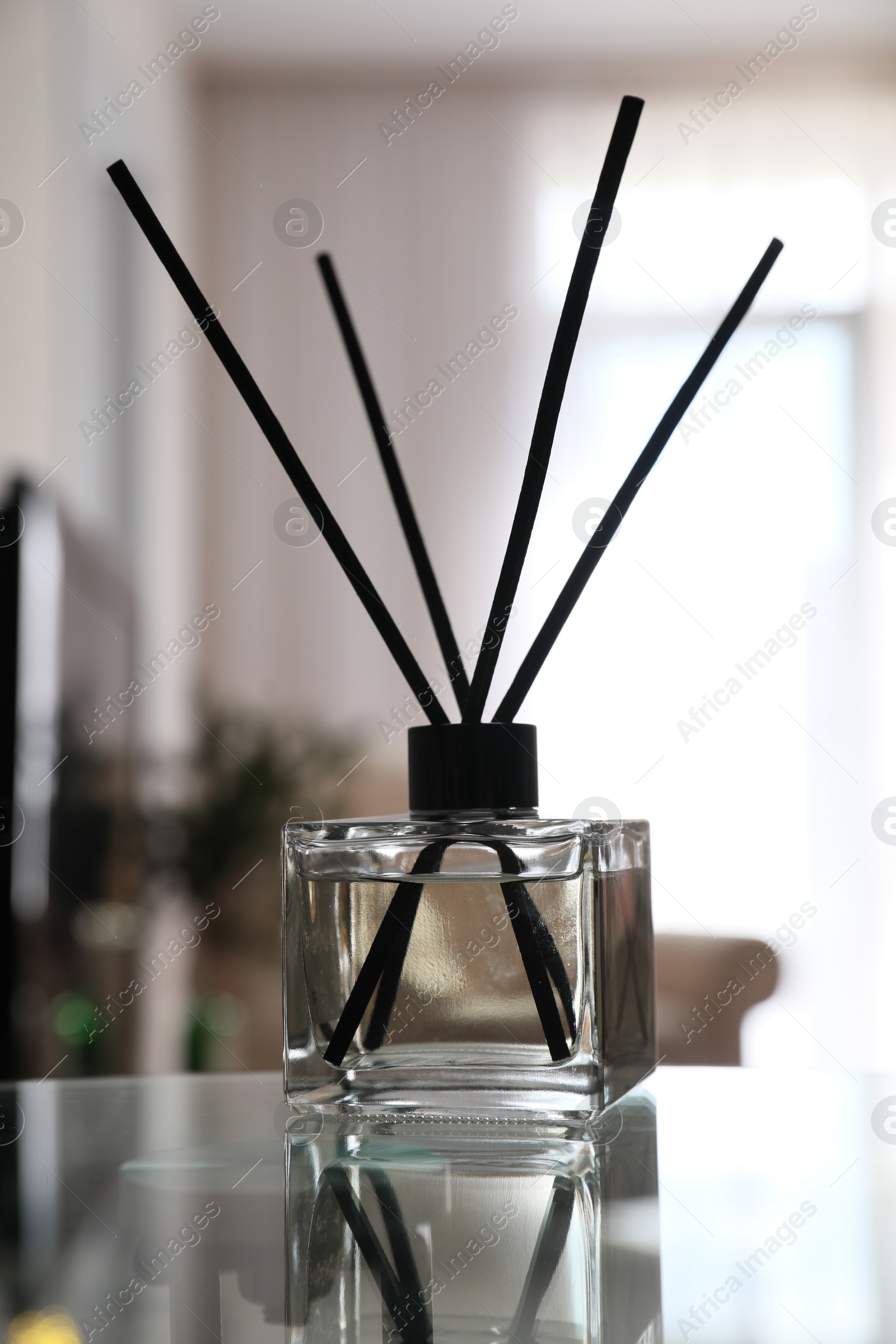 Photo of Aromatic reed air freshener on table indoors