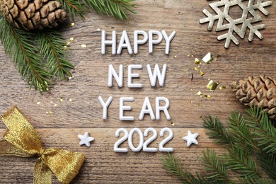 Flat lay composition with phrase Happy New Year 2022 and festive decor on wooden background