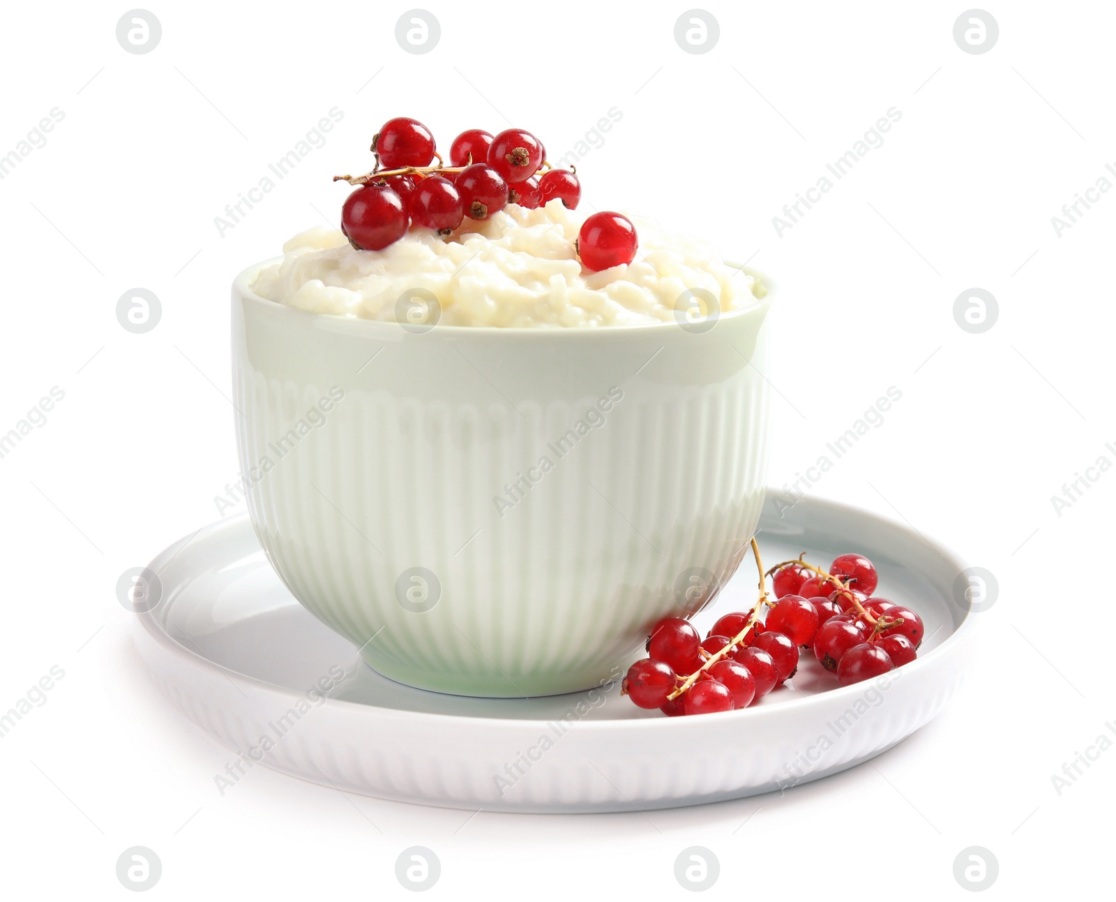 Photo of Creamy rice pudding with red currant in bowl on white background