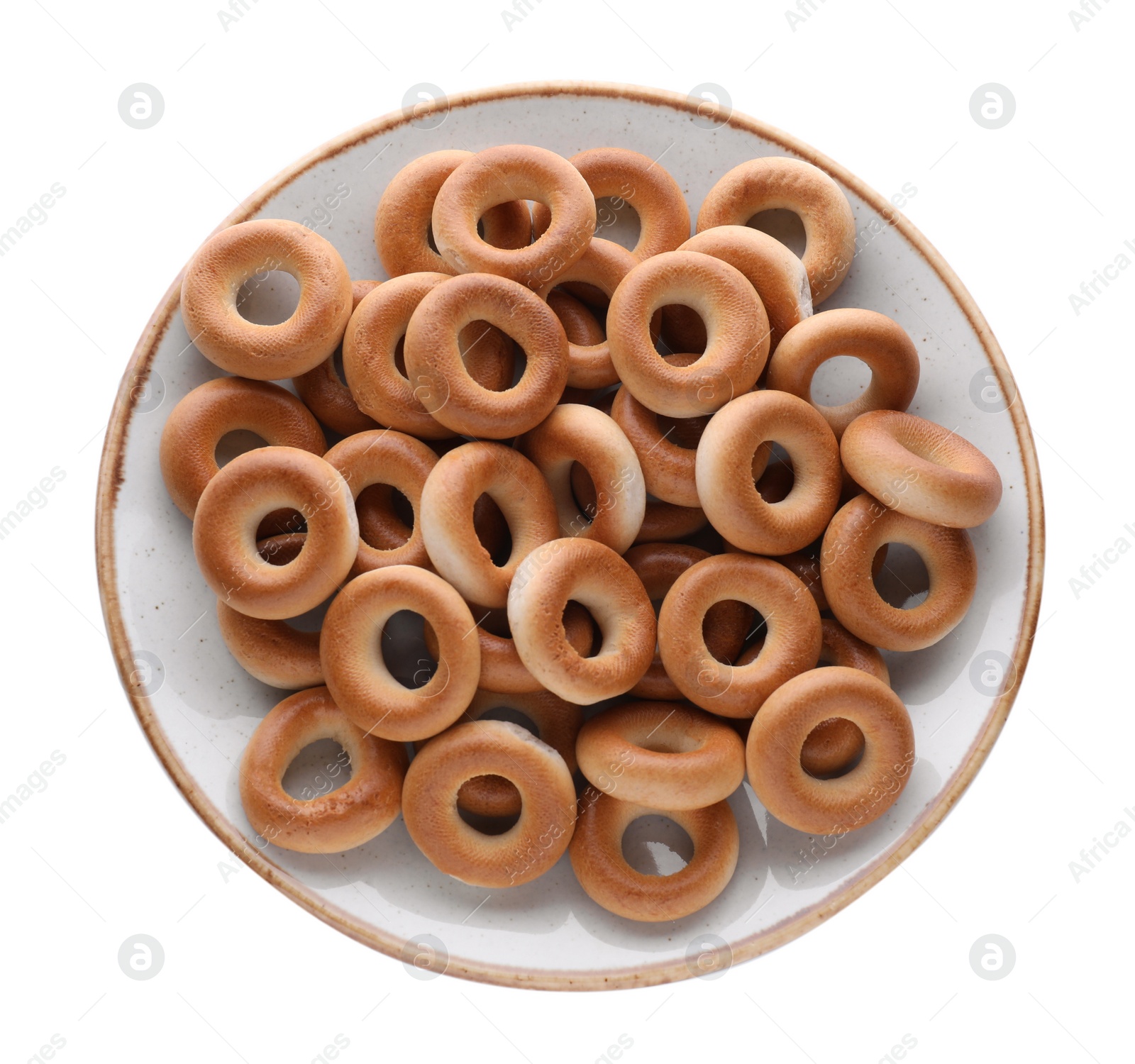 Photo of Plate with tasty dry bagels (sushki) isolated on white, top view