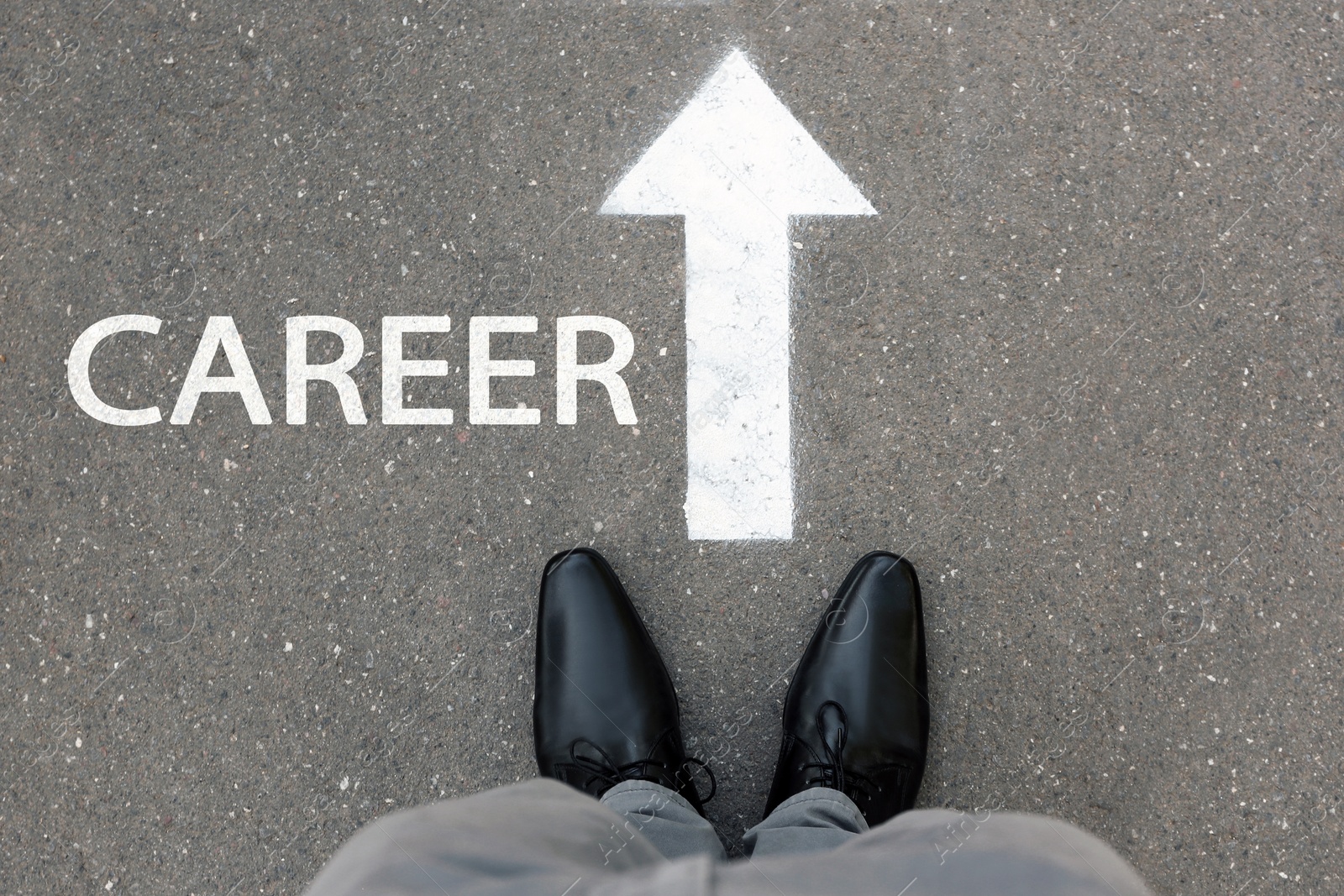 Image of Man standing near arrow on asphalt, top view. Career choice concept