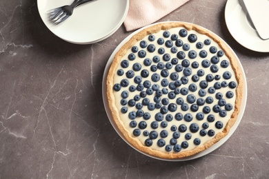 Photo of Flat lay composition with tasty blueberry cake and space for text on gray table