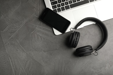 Photo of Flat lay composition with headphones, laptop and smartphone on table. Space for text