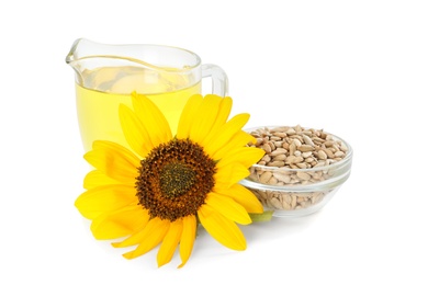 Photo of Sunflower, jug of oil and seeds on white background