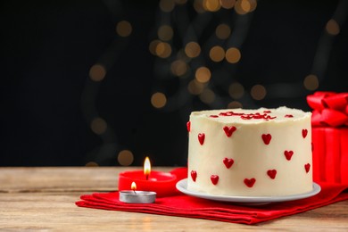 Photo of Bento cake, candles and gift box on wooden table, space for text. St. Valentine's day surprise
