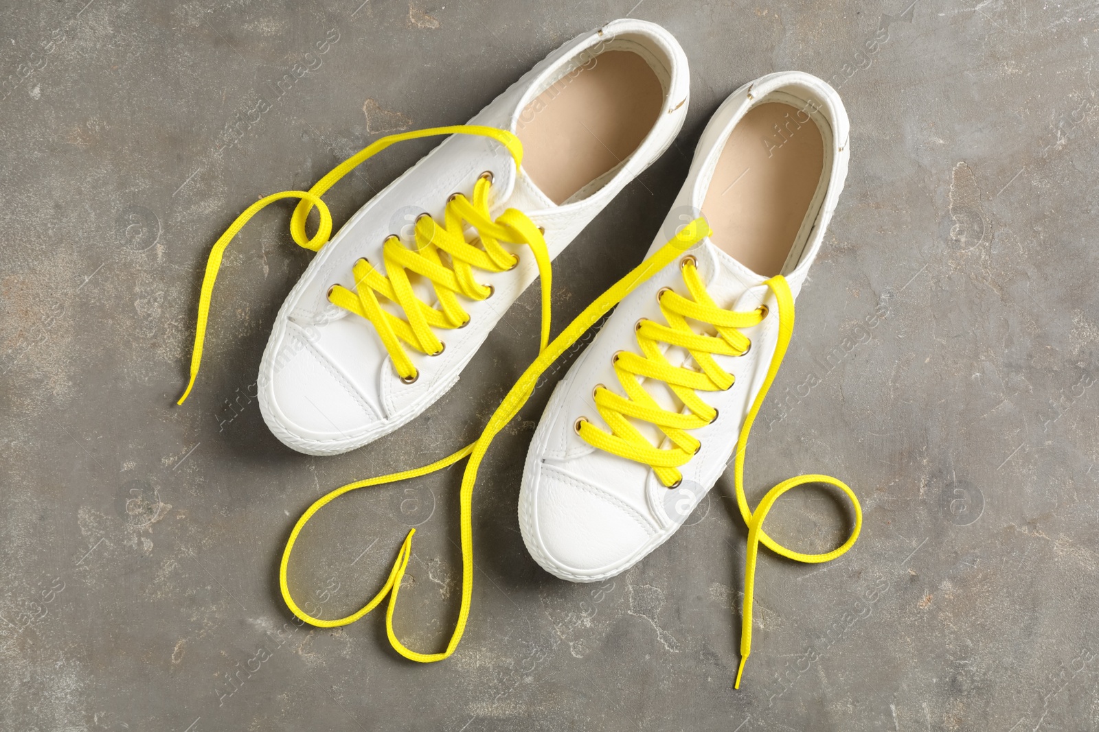 Photo of Pair of stylish shoes with yellow laces on grey background, flat lay