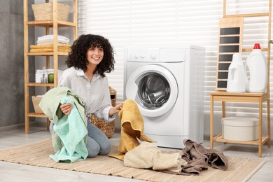 Photo of Woman with laundry near washing machine indoors