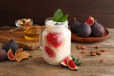 Photo of Delicious fig smoothie in mason jar on wooden table