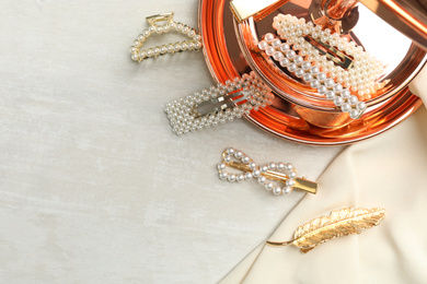 Photo of Beautiful different hair clips on white table, flat lay. Space for text