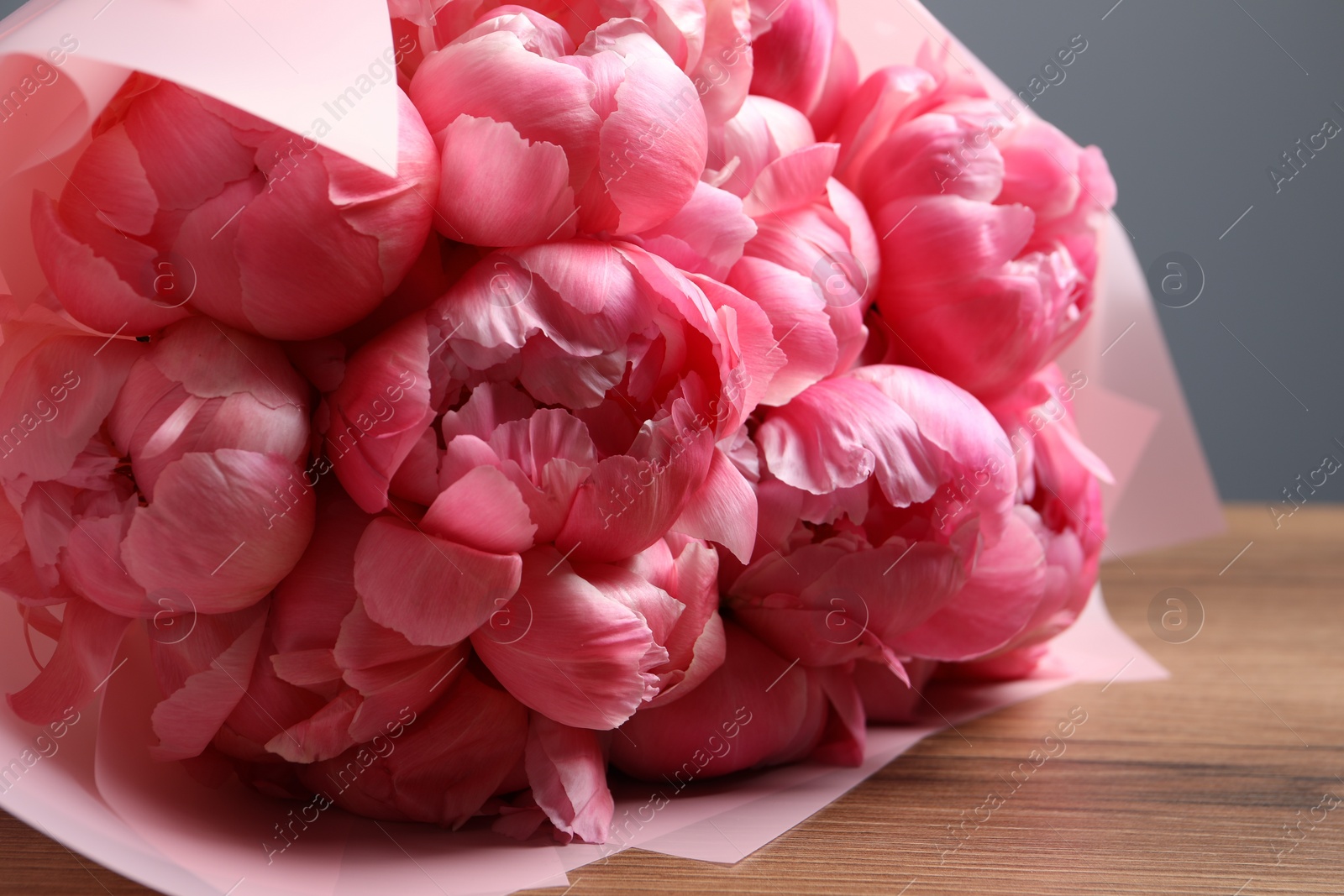 Photo of Bouquet of beautiful pink peonies on wooden table, closeup