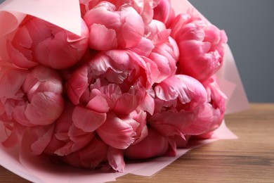 Photo of Bouquet of beautiful pink peonies on wooden table, closeup