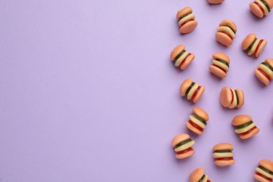 Photo of Tasty jelly candies in shape of burger on lilac background, flat lay. Space for text