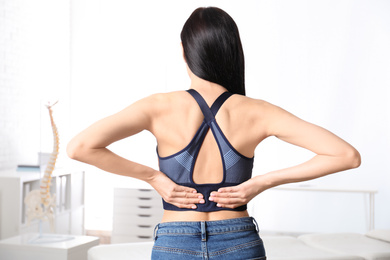 Photo of Woman suffering from lower back pain at clinic. Visiting orthopedist