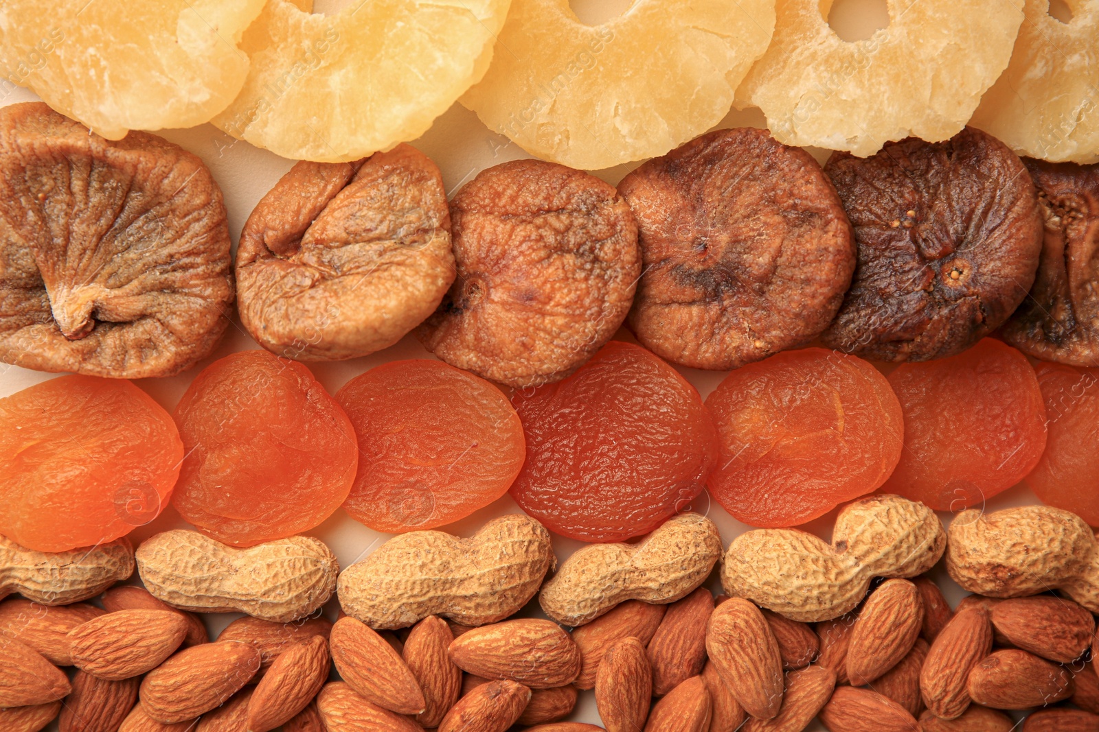 Photo of Different tasty nuts and dried fruits as background, top view