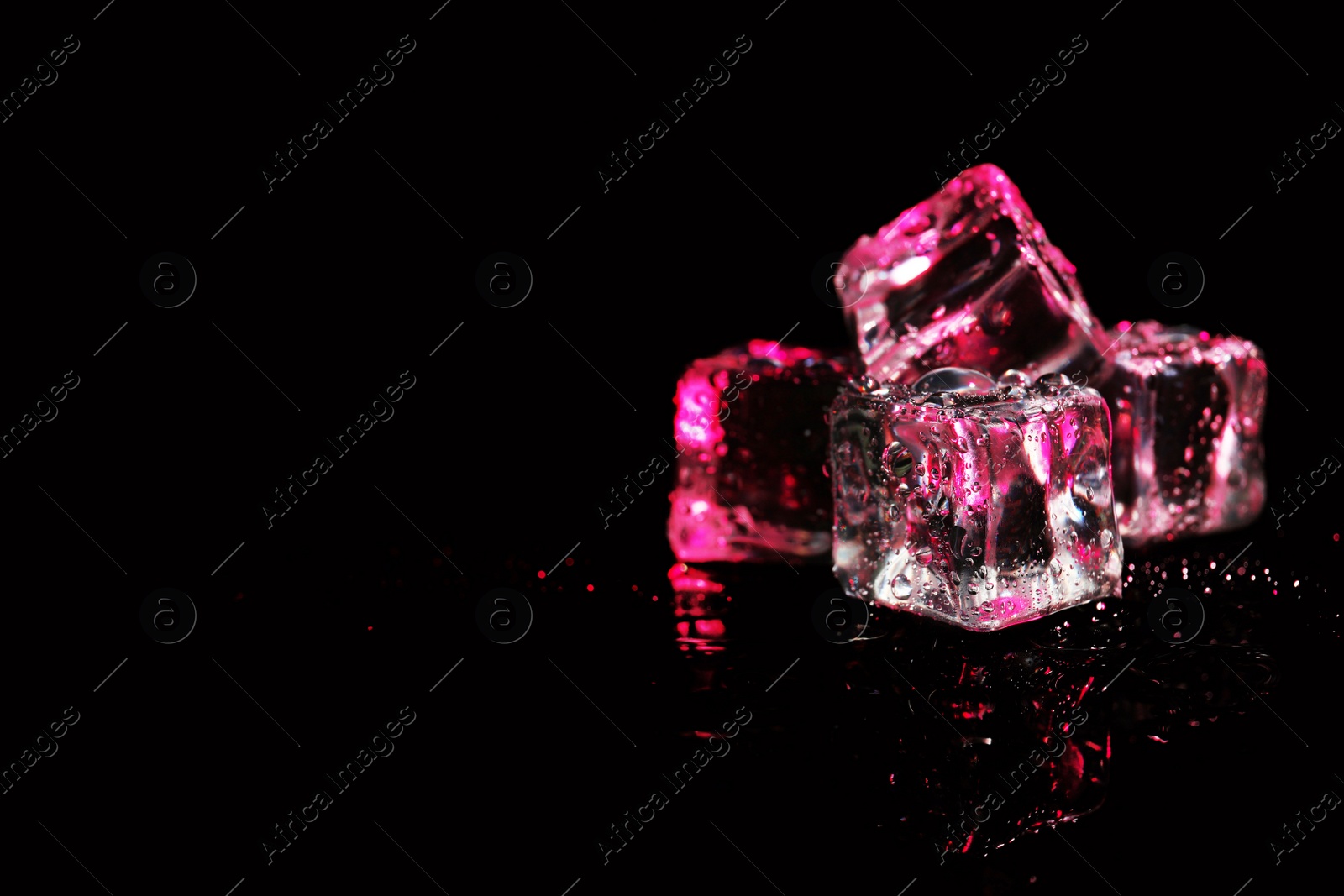 Photo of Pile of crystal clear ice cubes on black background. Space for text