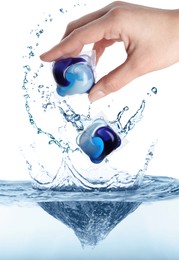 Image of Woman throwing laundry capsules into water on white background, closeup. Detergent pods