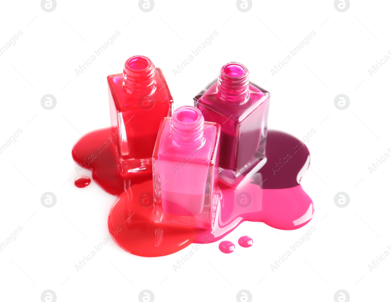 Photo of Spilled different nail polishes with bottles on white background