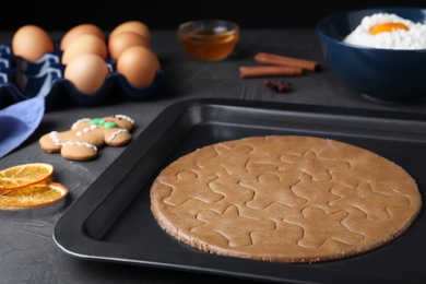 Making homemade gingerbread man cookies in baking dish on table, closeup